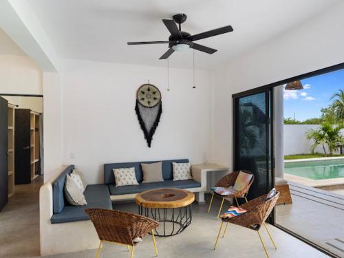 Casa Naay في جزيرة هول بوكس: غرفة معيشة مع أريكة وكراسي ومروحة سقف