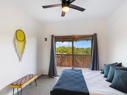 a bedroom with a bed and a ceiling fan at Casa Naay in Holbox Island