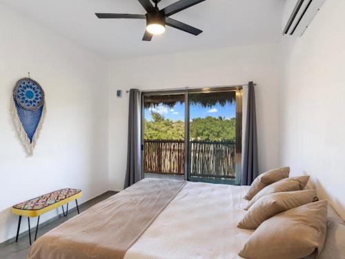 a bedroom with a large bed and a large window at Casa Naay in Holbox Island