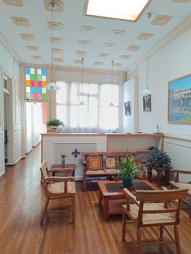 a living room with tables and chairs and a unintention at Hostal Tulio Porteño in Valparaíso