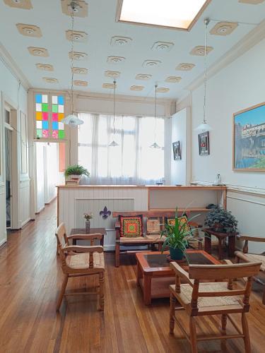 una sala de estar con mesas y sillas y una sala de estar independiente. en Hostal Tulio Porteño, en Valparaíso