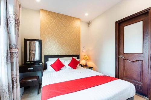 1 dormitorio con 1 cama grande con almohadas rojas en 518 Chariot Hotel, en Hanói
