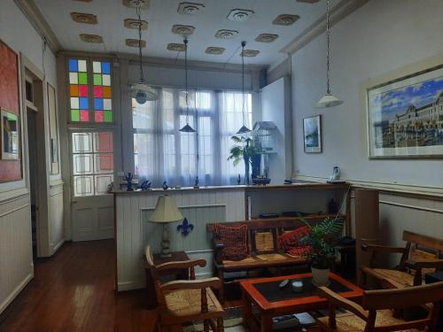 a living room with a table and chairs and a stained glass window at Hostal Tulio Porteño in Valparaíso