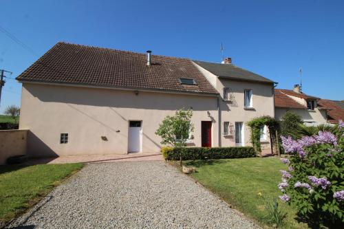 a white house with a red door and a yard at Champblanc in Arnac-la-Poste