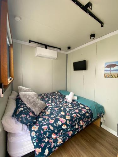 1 dormitorio pequeño con 1 cama y TV en Beautiful tiny house with outdoor area- Only 5 minute walk to the beach!, en Cape Paterson