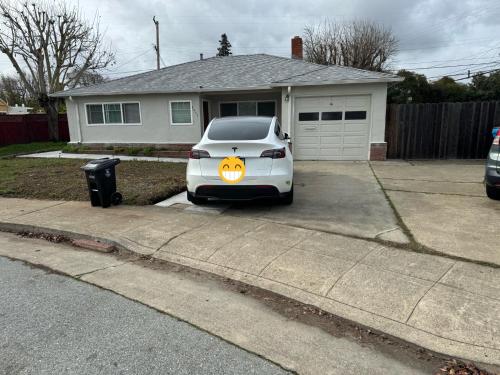 a white car parked in a driveway with a pumpkin sign on it at New remol modern tranquil house near SFO in San Mateo