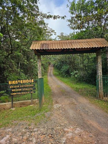 a sign on a dirt road next to a dirt road at Cerro Azul Mountain Retreat in Cerro Azul