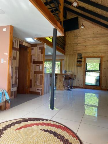 Habitación grande con paredes de madera y suelo de baldosa blanca. en Cabaña El Polux, ruta x-671, en Coyhaique
