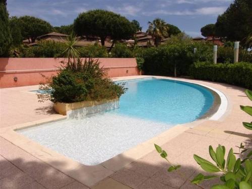 une grande piscine dans une cour avec dans l'établissement Appartement 3 pièces avec piscine, terrasse et WIFI - Le Lavandou - FR-1-251-561, au Lavandou