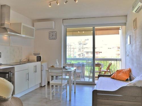 Il comprend une cuisine et un salon avec une table et une cuisine. dans l'établissement Studio cosy 4 pers, climatisé avec terrasse et parking, proche plage - Le Lavandou - FR-1-251-518, au Lavandou