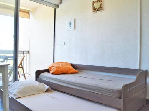 - un lit avec un oreiller orange dans l'établissement Studio cosy 4 pers, climatisé avec terrasse et parking, proche plage - Le Lavandou - FR-1-251-518, au Lavandou