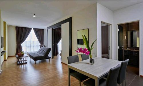 ein Wohnzimmer mit einem Tisch und Stühlen sowie ein Wohnzimmer in der Unterkunft Metra 308 Easy Suite in Ayer Keroh