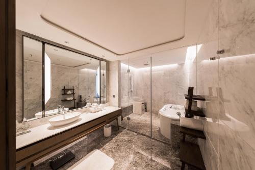 西安市にあるRenaissance Xi'an Hotelのバスルーム(シンク、バスタブ、鏡付)