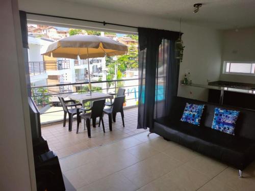 a dining room with a table and chairs and an umbrella at APARTASOLES SANTAFE in Santa Fe de Antioquia