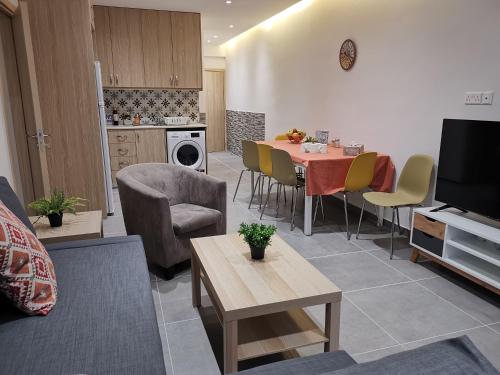 sala de estar con mesa y sillas y cocina en PERSEUS 3 BEDROOM Apartment 102 en Lárnaca