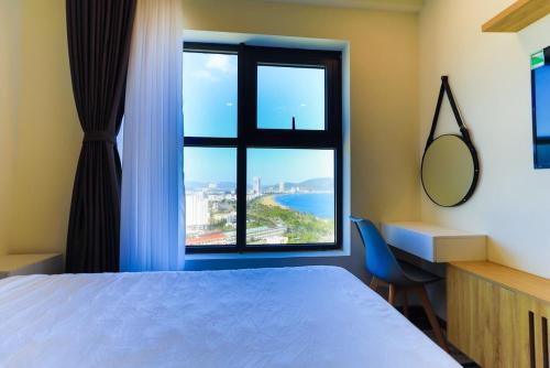 a bedroom with a bed and a large window at Flc Sea Tower Minh 1 in Quy Nhon