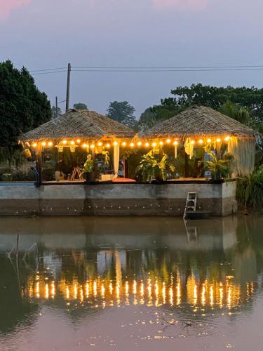 a restaurant with lights on the side of a body of water at ปีกไม้วิลล่าb2 