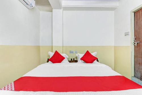 um quarto com uma cama grande e almofadas vermelhas em OYO Suraj Residency em Warangal