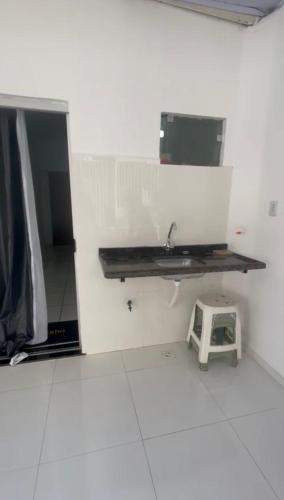 a bathroom with a sink and a shelf on the wall at AP térreo Ilhéus in Ilhéus