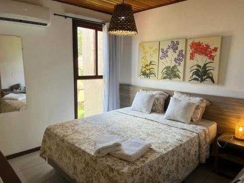 a bedroom with a bed with two towels on it at Pipa - Bosque da Praia Flat 14 in Pipa
