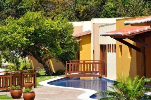 a house with a swimming pool in front of it at Pipa - Bosque da Praia Flat 14 in Pipa