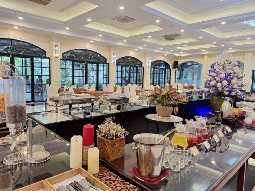 ニャチャンにあるTran Vien Dong Hotelの広い客室で、テーブル(グラスと花付)が備わります。