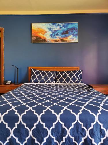 a bedroom with a bed with a blue wall at Relax Inn Rural Retreat- Marion - Atkins in Rural Retreat