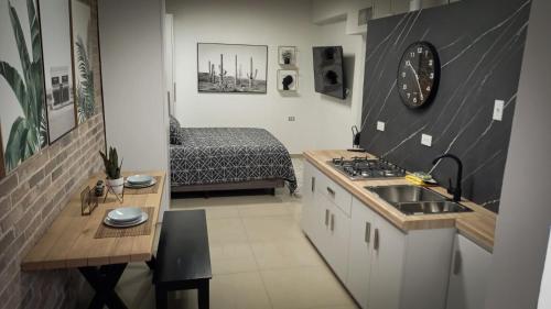 a kitchen with a sink and a stove in a room at Lujoso depa cerca del consulado. in Ciudad Juárez
