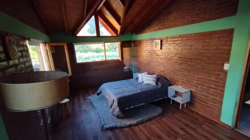 um quarto com uma cama e uma parede de tijolos em Esquel house em Esquel