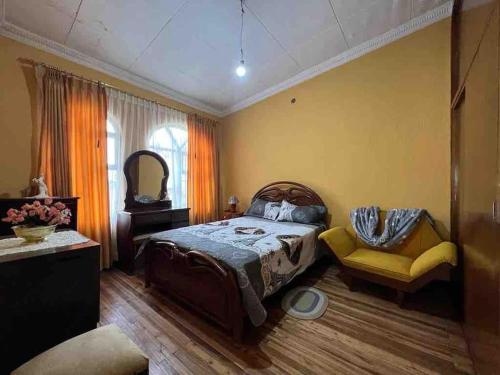 1 dormitorio con 1 cama, 1 silla y 1 ventana en Villa Paquita - Arco de Bellavista, en Riobamba