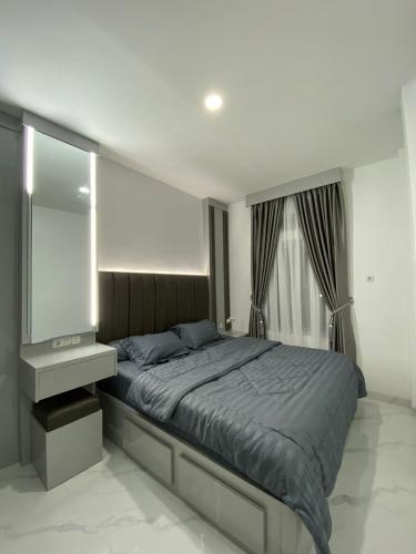 sypialnia z dużym łóżkiem i lustrem w obiekcie Villa Shafa Marwa w mieście Bukittinggi
