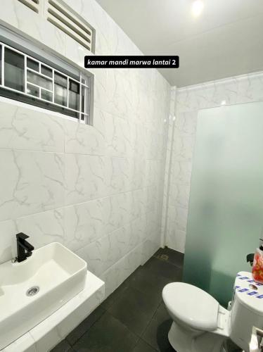 biała łazienka z umywalką i toaletą w obiekcie Villa Shafa Marwa w mieście Bukittinggi