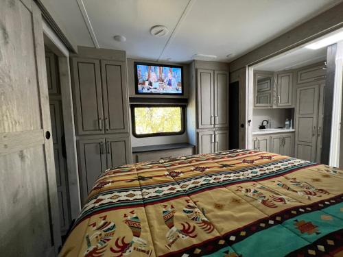 1 dormitorio con 1 cama y TV. en JMA Alpine Inn, en Riverton