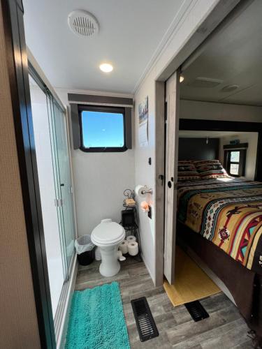Dormitorio pequeño con cama y aseo en JMA Alpine Inn, en Riverton