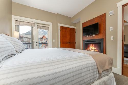 a bedroom with a bed and a fireplace at Solara Suite with Indoor Pool - Hot tub -Parking - GYM in Canmore