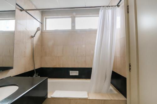 a bathroom with a tub and a sink and a shower at Java Paragon Hotel & Residences in Surabaya