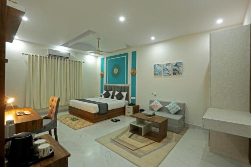 a bedroom with a bed and a couch and a table at Hriday Bhoomi - Luxury Cottages & Villa in Jim Corbett in Jhirna