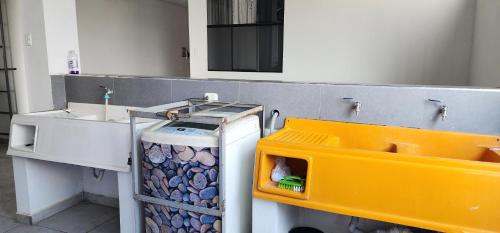 ein Badezimmer mit einem Waschbecken und einem Mülleimer in der Unterkunft Makasai Habitaciones in Puerto Maldonado
