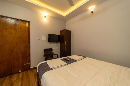 a bedroom with a large bed and a wooden cabinet at Lax Residency, White Town, Pondicherry in Puducherry