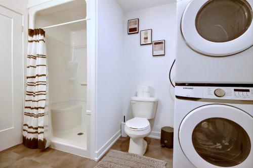 y baño con lavadora y aseo. en Chalet inspired home in Niagara, en Welland