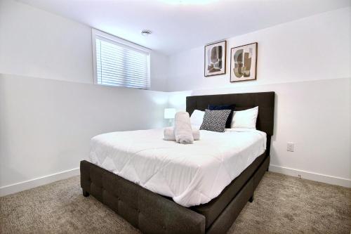 1 dormitorio con 1 cama grande con sábanas y almohadas blancas en Chalet inspired home in Niagara, en Welland