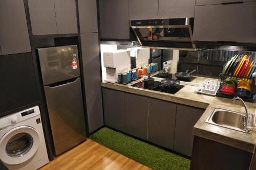 a small kitchen with a washing machine and a dishwasher at Kota Kinabalu family Home in Kota Kinabalu