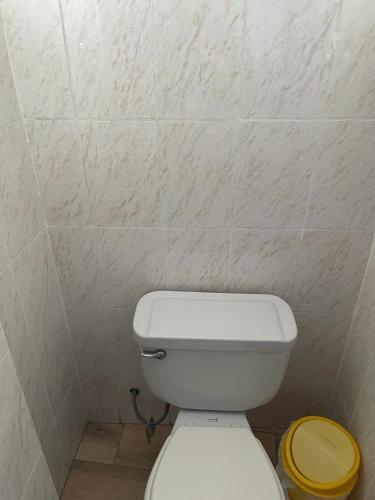 a bathroom with a white toilet with a yellow lid at Hotel Hispano in Cajamarca