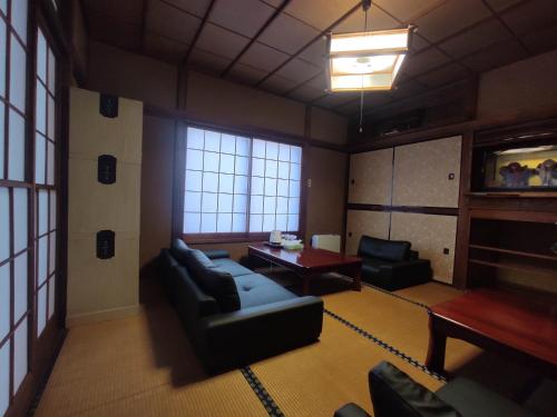 a living room with a couch and a table at Guesthouse Kincha 駅東口 in Utsunomiya