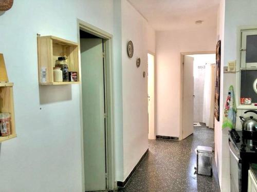 a kitchen with white walls and a hallway with a stove at Casa-Apt de 2 Dormitorios Perfecta Ubicacion in Piriápolis