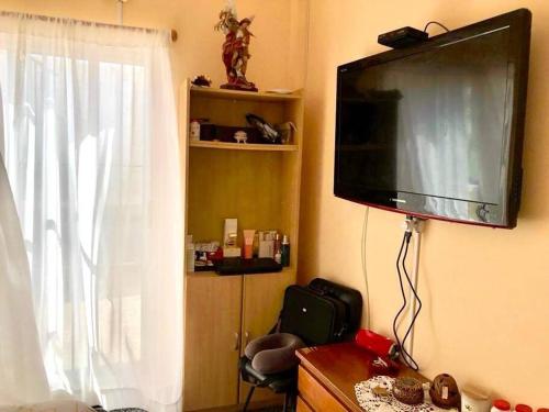 a flat screen tv hanging on a wall with a window at Casa-Apt de 2 Dormitorios Perfecta Ubicacion in Piriápolis