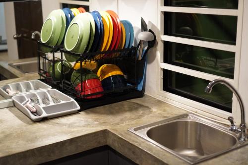 a kitchen counter with a dish rack with plates and utensils at Kota Kinabalu family Home in Kota Kinabalu