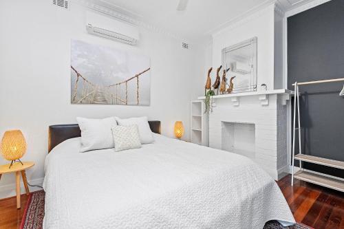 une chambre blanche avec un lit et une cheminée dans l'établissement Cottage Gem - 2br Parkside Retreat, à Bicton