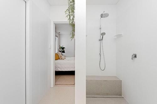 Il comprend une chambre et une salle de bains blanche pourvue d'une douche. dans l'établissement Cottage Gem - 2br Parkside Retreat, à Bicton