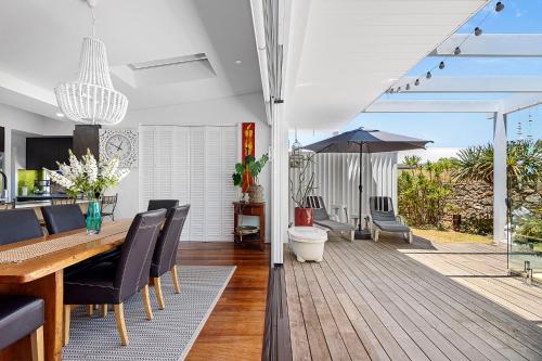 a dining room with a table and an umbrella at Cottage Gem - 2BR Parkside Retreat in Bicton